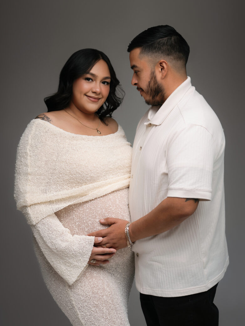 Couple embracing during a studio maternity photoshoot in Phoenix